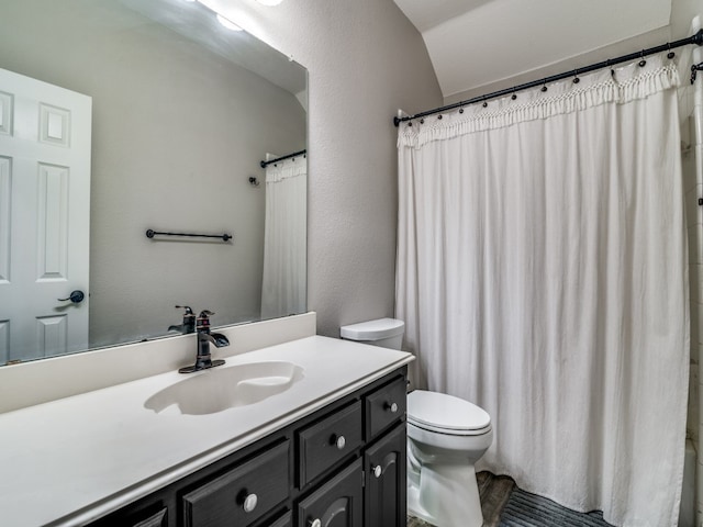 bathroom featuring walk in shower, vanity, and toilet