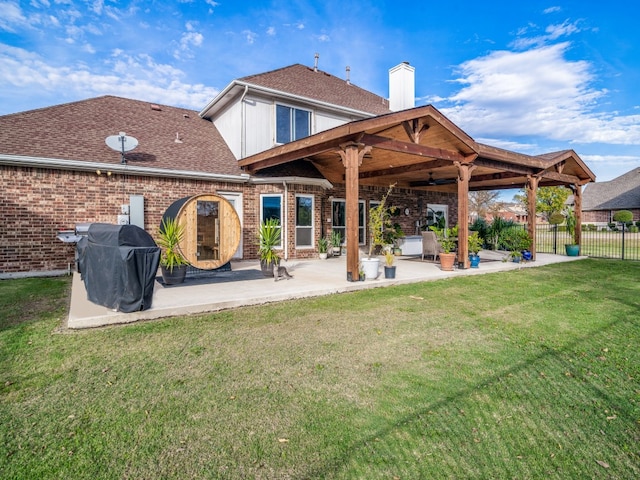 rear view of house with a lawn and a patio