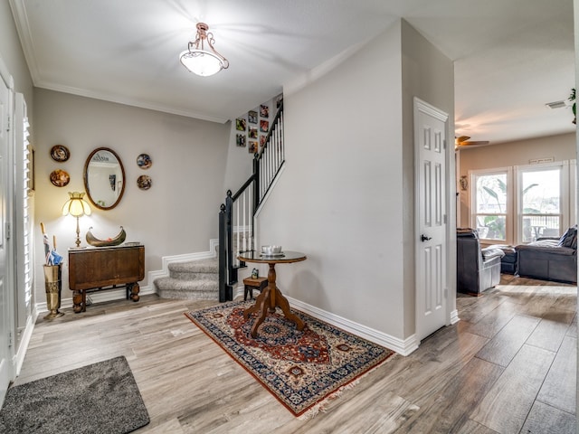 foyer entrance with crown molding, ceiling fan, and hardwood / wood-style flooring