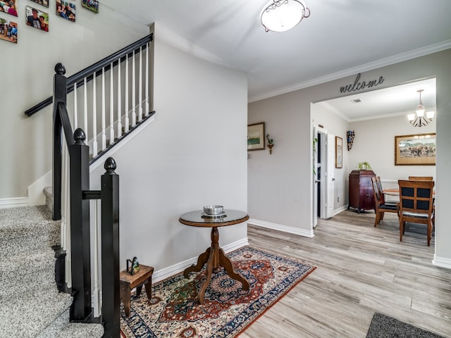 entryway featuring light hardwood / wood-style flooring, a chandelier, and ornamental molding