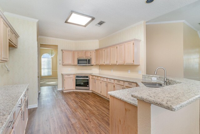 kitchen with sink, stainless steel appliances, light hardwood / wood-style flooring, a textured ceiling, and ornamental molding