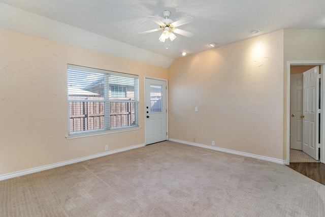 empty room with light carpet, ceiling fan, and lofted ceiling