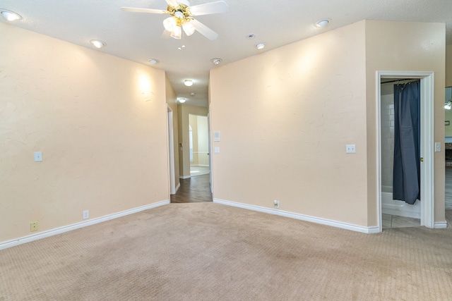 carpeted spare room featuring ceiling fan