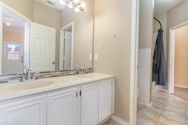 bathroom featuring tile patterned flooring, vanity, and toilet