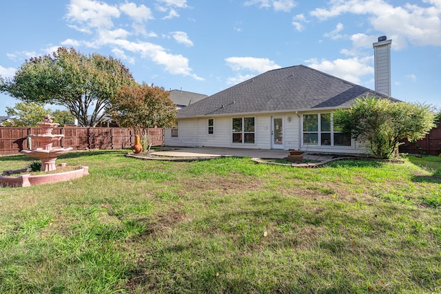 back of property with a patio area and a yard