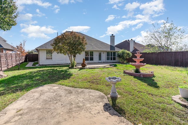 rear view of property featuring a lawn and a patio area