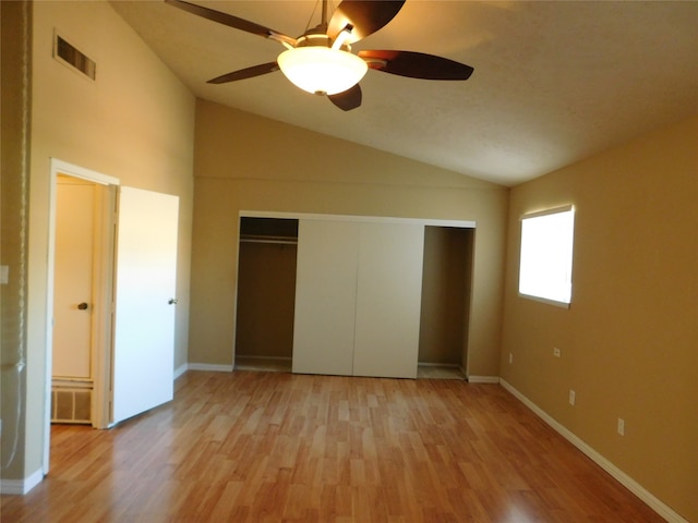 unfurnished bedroom featuring ceiling fan, light hardwood / wood-style floors, a closet, and vaulted ceiling