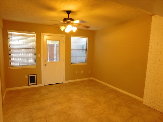 interior space with ceiling fan and a textured ceiling