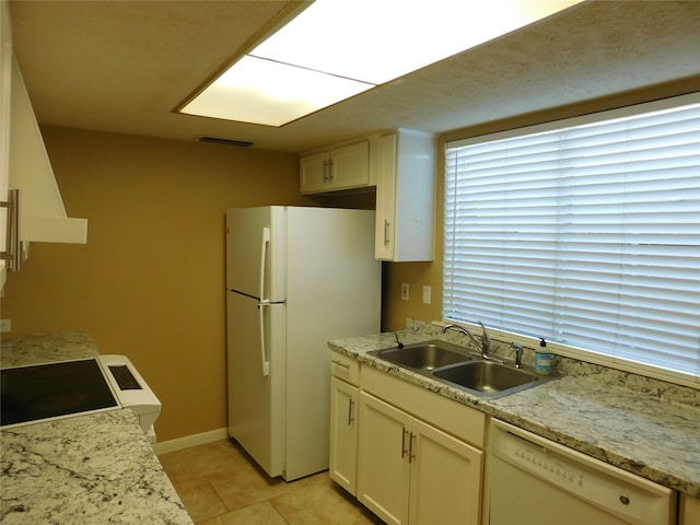 kitchen featuring white appliances, sink, and light tile patterned floors