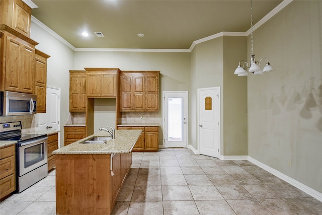 kitchen featuring appliances with stainless steel finishes, backsplash, sink, a chandelier, and an island with sink