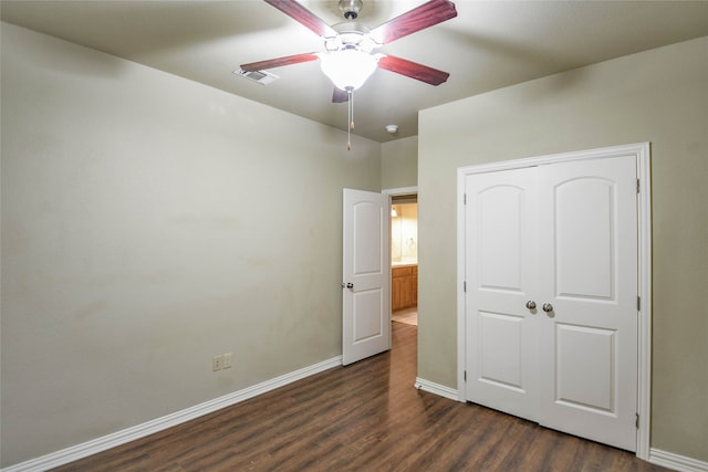 unfurnished bedroom with dark hardwood / wood-style floors, ceiling fan, and a closet