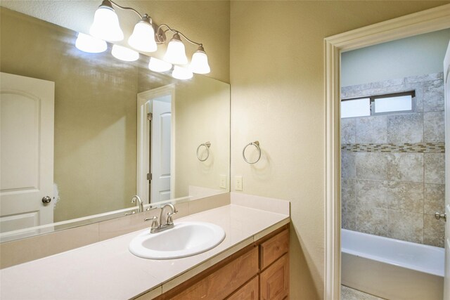 bathroom with vanity and tiled shower / bath combo