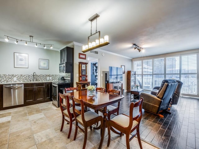 dining room with crown molding and sink