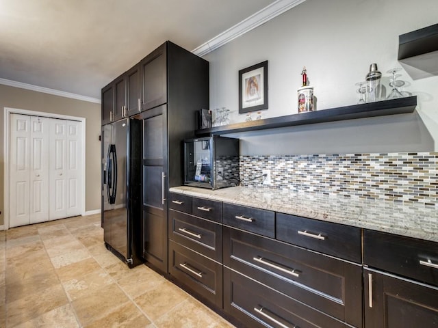 kitchen featuring crown molding, light stone countertops, backsplash, and black fridge with ice dispenser