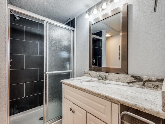 bathroom with vanity, beverage cooler, a textured ceiling, and a shower with shower door