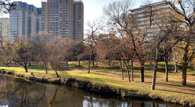 view of home's community with a water view and a lawn