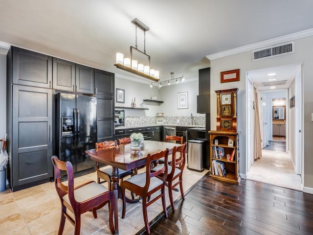 dining room featuring crown molding and light hardwood / wood-style flooring