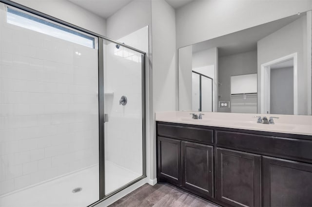 bathroom with vanity, wood-type flooring, and a shower with door