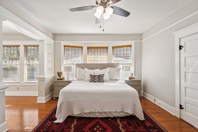 bedroom with hardwood / wood-style floors, ceiling fan, and multiple windows