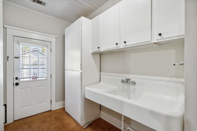 laundry area featuring parquet floors and sink