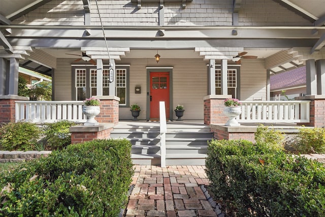 view of exterior entry with ceiling fan and a porch