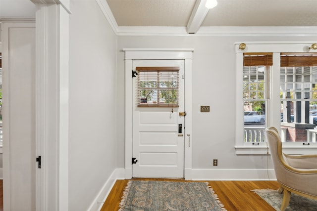 entryway featuring beam ceiling, wood-type flooring, and ornamental molding