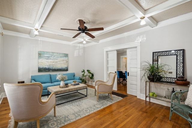 living room with beam ceiling, ceiling fan, coffered ceiling, dark hardwood / wood-style flooring, and a textured ceiling