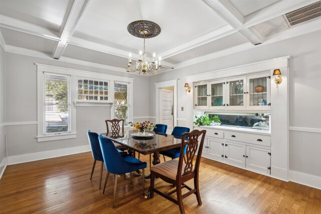 dining space with beamed ceiling, a chandelier, wood-type flooring, and coffered ceiling