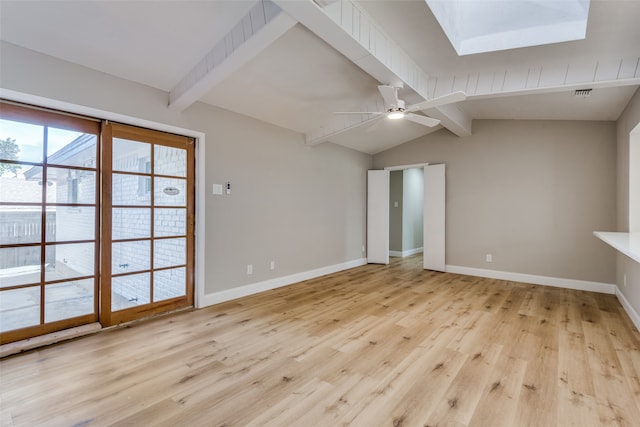 unfurnished living room featuring light wood-type flooring, ceiling fan, and vaulted ceiling with skylight