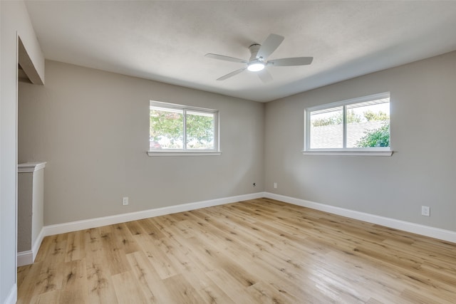 unfurnished room featuring plenty of natural light, ceiling fan, and light wood-type flooring