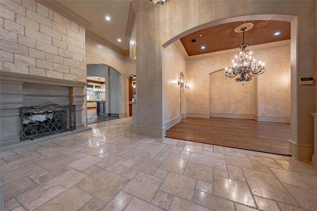 entrance foyer featuring a large fireplace, ornamental molding, and a high ceiling