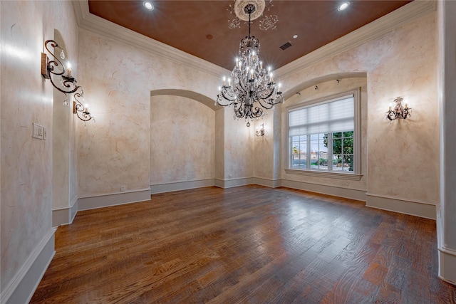 unfurnished dining area featuring hardwood / wood-style flooring, ornamental molding, and a chandelier