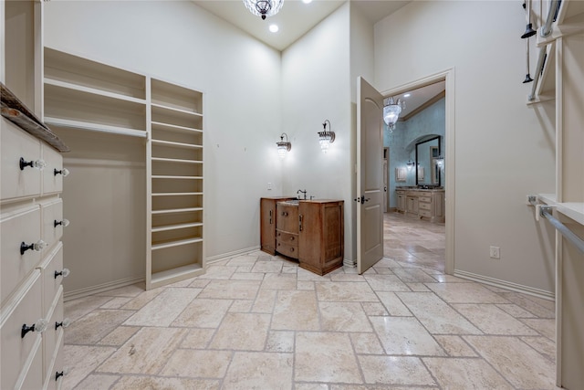 spacious closet with a high ceiling and an inviting chandelier