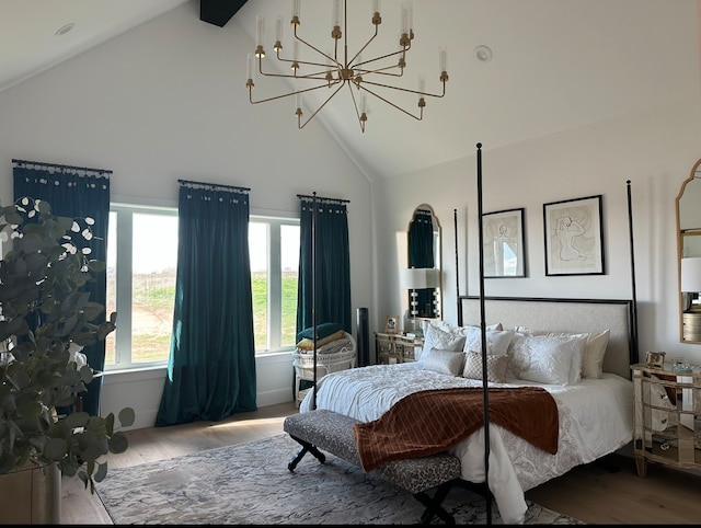 bedroom with high vaulted ceiling, a notable chandelier, and light hardwood / wood-style floors