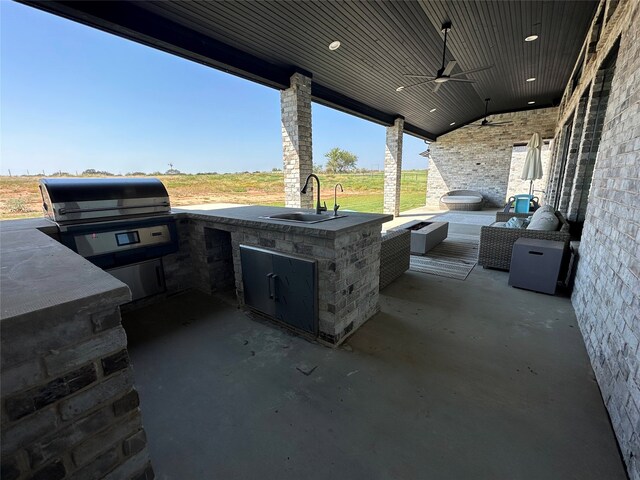 view of patio / terrace featuring area for grilling, sink, ceiling fan, and an outdoor kitchen