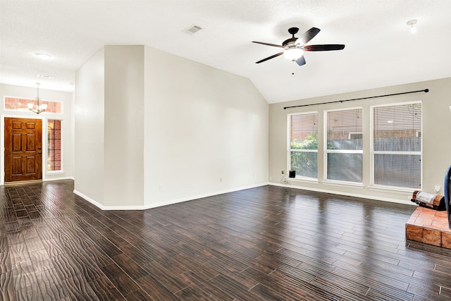 unfurnished living room with a textured ceiling, ceiling fan with notable chandelier, lofted ceiling, and dark wood-type flooring