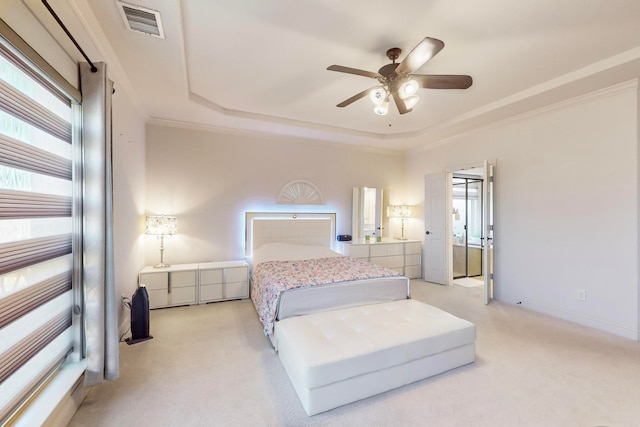 carpeted bedroom featuring crown molding, a tray ceiling, and ceiling fan