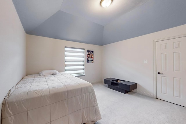 bedroom with lofted ceiling and light carpet