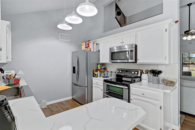 kitchen with white cabinetry, tasteful backsplash, appliances with stainless steel finishes, and hanging light fixtures