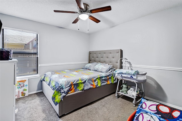 bedroom with ceiling fan, carpet floors, and a textured ceiling