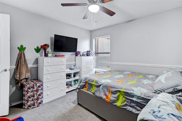 carpeted bedroom with ceiling fan and a textured ceiling