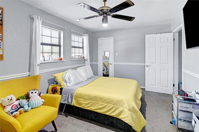 bedroom featuring ceiling fan, carpet floors, and a textured ceiling