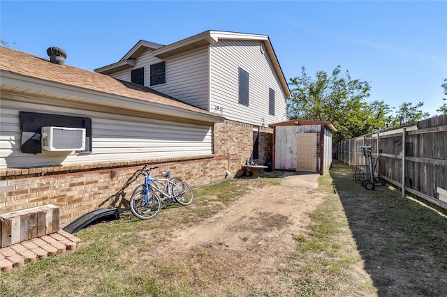 view of property exterior featuring cooling unit and a shed