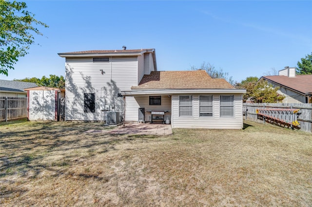 rear view of house with a patio, a storage unit, a yard, and central air condition unit