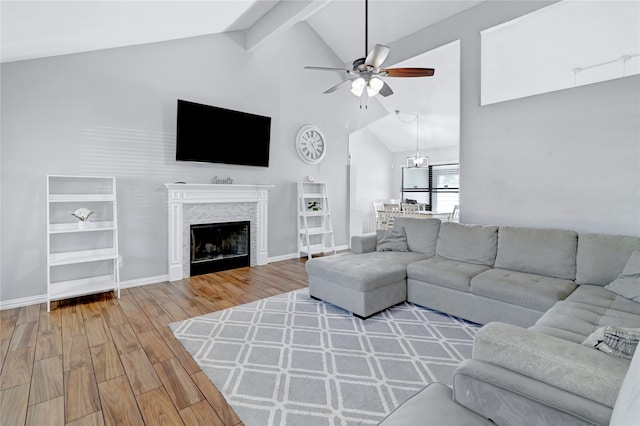 living room with hardwood / wood-style floors, beamed ceiling, high vaulted ceiling, and ceiling fan