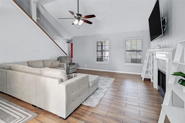 living room featuring hardwood / wood-style flooring, high vaulted ceiling, and ceiling fan