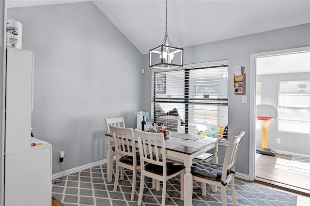 dining space featuring lofted ceiling, a chandelier, and hardwood / wood-style floors