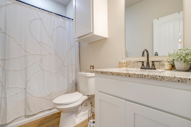 bathroom featuring toilet, hardwood / wood-style floors, and vanity