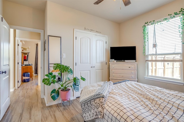 bedroom featuring ceiling fan, a closet, and light hardwood / wood-style flooring