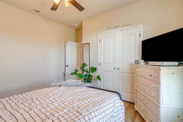 bedroom featuring ceiling fan, a closet, and light hardwood / wood-style flooring